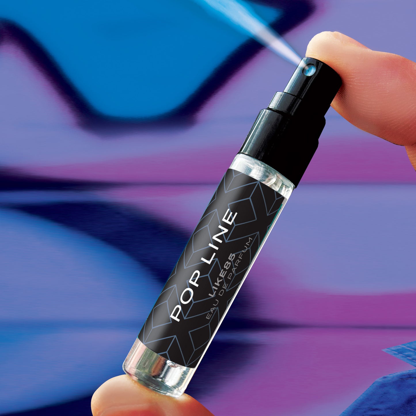 Black and silver pop line perfume bottle held by a hand with a colorful abstract background