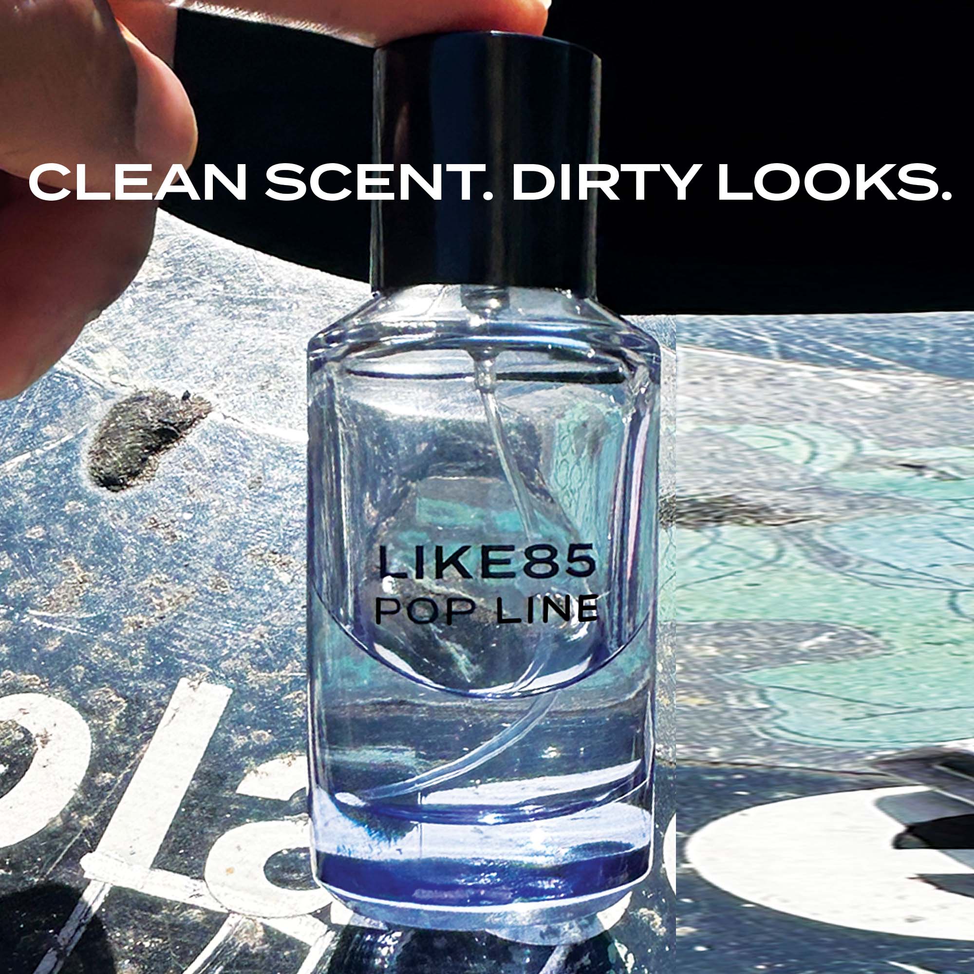 Bottle of LIKE85 Pop Line perfume with text 'Clean Scent. Dirty Looks.' on a textured surface.